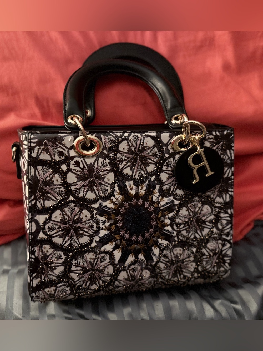 Source unknown. Black and Cream Embossed Floral Satchel with Gold Charm